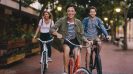 Bike-friendly cities around the world - Three young people cycling down the street