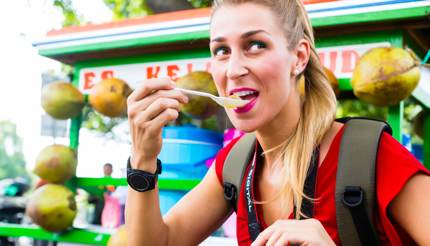 A tourist enjoying street food in Jakarta