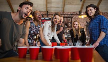 Friends playing beer pong