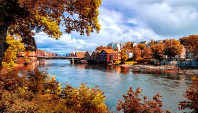 View through autumn foliage to Nidelva river, Trondheim city, Norway