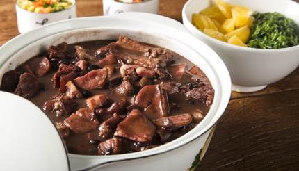 Feijoada - beef, pork and black beans are cooked over low heat in a thick clay pot to make a rich stew