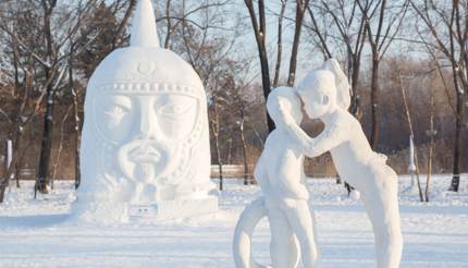 Snow sculpture of a girl whispering in a boy's ear