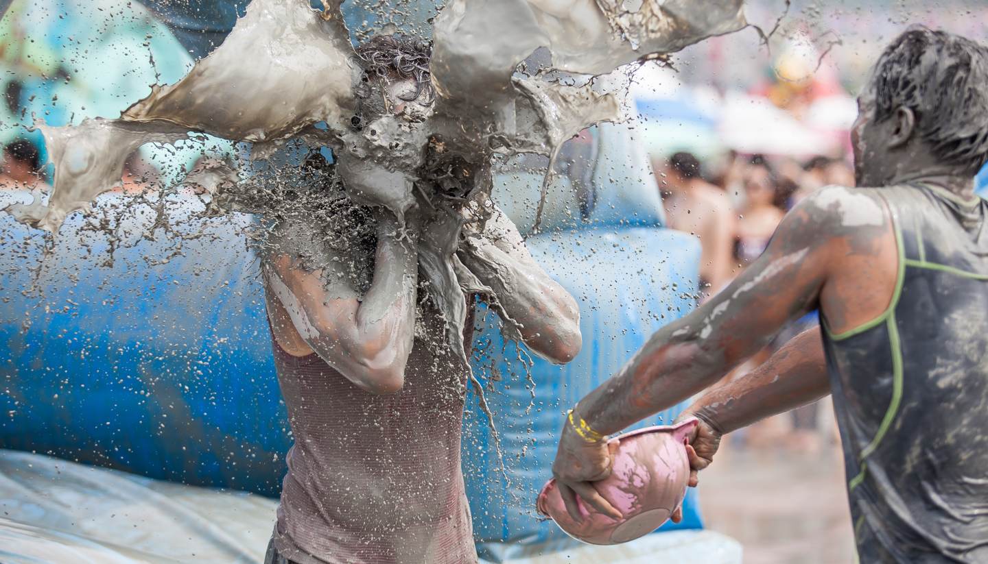 The 20 craziest festivals in the world - Mud-covered man throwing mud at woman