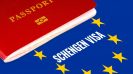 A guide to Schengen visas - Red passport on Europe flag background with Schengen Visa in the circle of stars