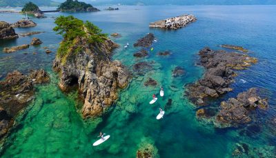 People standup paddle boarding in Takahama, Japan