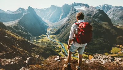 Man with a red backpack hiking alone in Norway