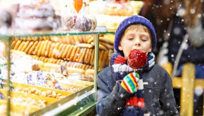 Child enjoying candy apple Christmas market